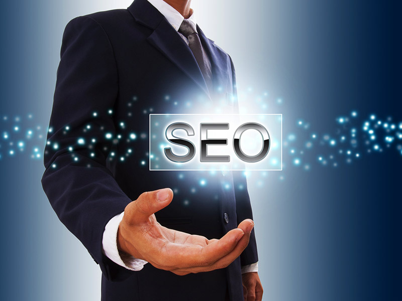 A professional in a suit holding a glowing SEO sign with digital network points radiating from the palm of their hand.